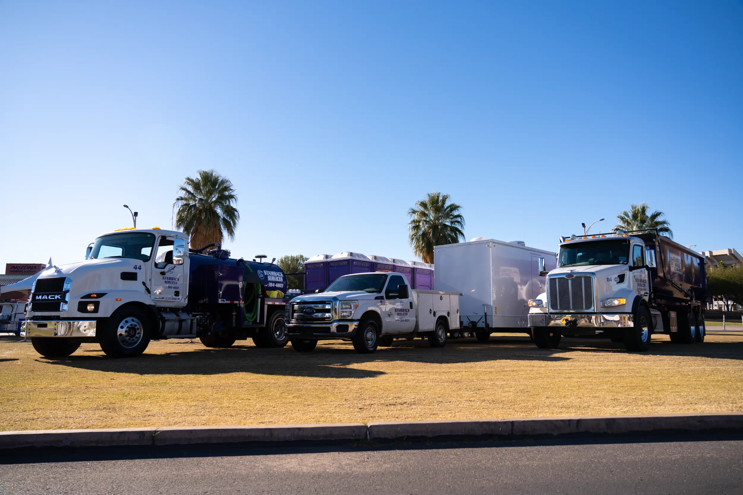 Stamback Services trucks lined up next to each other in a field