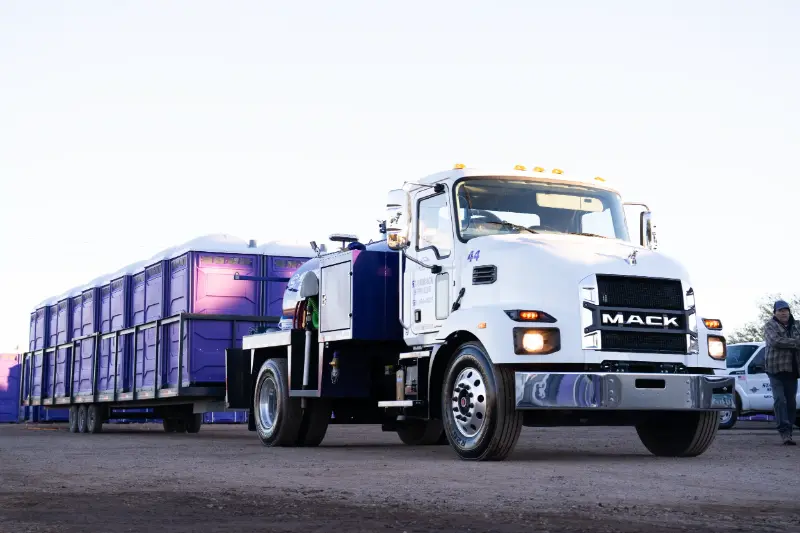 Stamback Services truck hauling porta potties